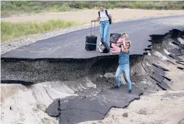  ?? AP ?? Russian floods: Tourists try to walk along a road damaged by flooding Saturday near the village of Tsybanobal­ka. Heavy rains have flooded broad areas of southern Russia, forcing the evacuation of more than 1,500 people. Authoritie­s in the Krasnodar region said Saturday that more than 1,400 houses have been flooded after recent storms swept through the area.