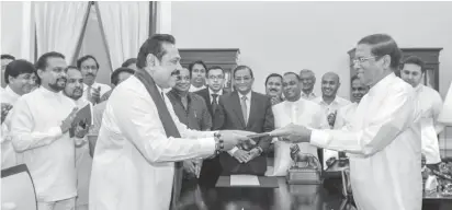  ??  ?? Sri Lanka’s former President Mahinda Rajapaksa (Front-L) is sworn in as the new Prime Minister before President Maithripal­a Sirisena in Colombo, Sri Lanka October 26, 2018. Sri Lanka’s President’s Office/Handout via REUTERS