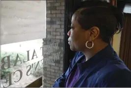  ?? ALLEN G. BREED — THE ASSOCIATED PRESS ?? Alesia Horton, director of the West Alabama Women's Center in Tuscaloosa, looks out the window at protesters on Tuesday. A deeply religious woman, she says of those who picket the clinic: “God isn't theirs. God is all of ours.”