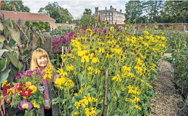  ??  ?? The National Trust’s Ham House, in Richmond, is offering visitors such as Kim Conner, above, the chance to a pick blooms from its historic walled kitchen garden. For a suggested donation of £10 visitors can fill their own buckets with flowers