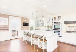  ?? Photos by Auslander Kasindorf Group/Keller Williams Realty ?? Left: The dining room at 1249 Shippan Ave. in Stamford features a fireplace. Right: The kitchen has a 6-by-9-foot island in the middle with white marble and stainless steel appliances.