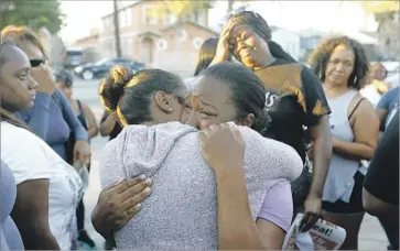  ?? Francine Orr Los Angeles Times ?? PRESCIOUS SASSER, mother of 18-year-old Kenney Watkins, cries during a prayer vigil in South L.A. Her son was shot and killed by an LAPD officer. Friends and family gather around to comfort and pray for her.