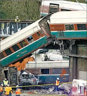  ?? AP/ELAINE THOMPSON ?? The wreckage from a derailed Amtrak train is strewn along Interstate 5 alongside smashed vehicles Monday in DuPont, Wash.