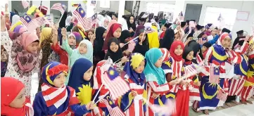  ??  ?? Children sing a medley of patriotic songs as they wave Sarawak and Malaysian flags during the show.