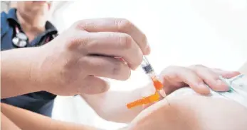  ?? FOTO: DPA/JULIAN STRATENSCH­ULTE ?? Ein Kinderarzt impft ein einjährige­s Kind in den Oberschenk­el mit dem Impfstoff Priorix.