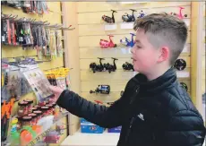  ?? 51_a10FyneTac­kle_newshop16 ?? Alfie Campbell was one of the first customers through the door, pictured browsing fishing lures.