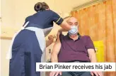  ??  ?? Brian Pinker receives his jab