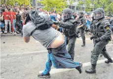  ?? FOTO: DPA ?? Nackte Tatsachen: Polizisten drängen auf der Theodor-Heuss-Straße einen Mann ab.