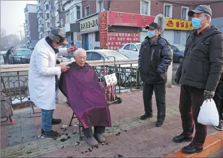  ?? HUANG JINKUN / FOR CHINA DAILY ?? An elderly resident of Shenyang, Liaoning province, gets a haircut on the street in January. Such barbers are popular with seniors in the provincial capital because they are cheap and convenient.