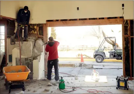  ?? SEAN D. ELLIOT/THE DAY ?? Workers chisel out the old vault in the former Washington Trust building Thursday in Olde Mistick Village to make way for Pink Basil, a Thai food restaurant.