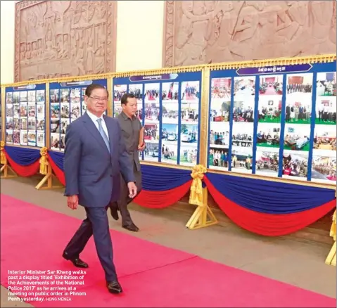  ??  ?? Interior Minister Sar Kheng walks past a display titled ‘Exhibition of the Achievemen­ts of the National Police 2017’ as he arrives at a meeting on public order in Phnom Penh yesterday.