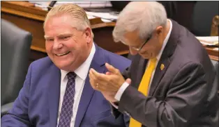  ?? CP PHOTO ?? Ontario’s Premier Doug Ford (left) is applauded by Finance Minister Vic Fedeli during Question Period at the Ontario Legislatur­e in Toronto on Thursday.