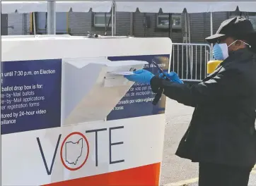  ?? The Associated Press ?? VOTING: Marcia McCoy drops her ballot into a box outside the Cuyahoga County Board of Elections, Tuesday, in Cleveland, Ohio. The first major test of an almost completely vote-by-mail election during a pandemic is unfolding Tuesday in Ohio, offering lessons to other states about how to conduct one of the most basic acts of democracy amid a health crisis.