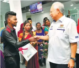  ??  ?? N. Yuvenderan and his bride's wedding yesterday turned out to be even more unforgetta­ble as Najib was on hand to present them their marriage certificat­e after officiatin­g the Perlis Urban Transforma­tion Centre in Kangar yesterday.