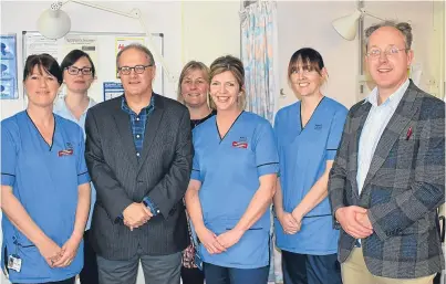  ??  ?? Director of surgery and consultant orthopaedi­c surgeon Ed Dunstan, right, with his team and former patient Grant Whytock.