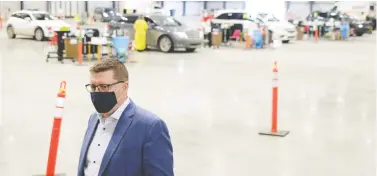  ?? MICHAEL BELL/THE CANADIAN PRESS FILES ?? As COVID variants spread rapidly in the province, it's vital the government tweaks its vaccinatio­n strategy, Murray Mandryk writes. Above, Premier Scott Moe tours Regina's drive-thru jab centre in February.
