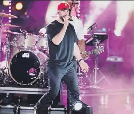  ?? Al Wagner AP ?? SAM HUNT sings at the CMT Music Awards after strolling down a city street.