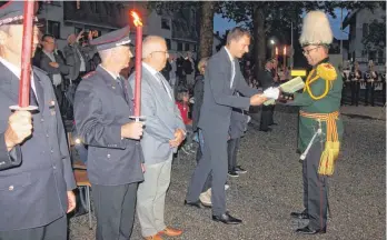  ?? FOTOS: SUSI WEBER ?? Die Bürgerwehr Amtzell verabschie­det Clemens Moll (rechts) mit einem Zapfenstre­ich. Moll beginnt seinen Posten als Weingarten­er Oberbürger­meister im Juli.