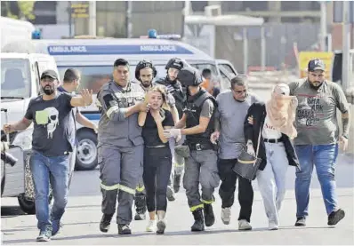 ?? Joseph Eid / AFP ?? Serveis mèdics libanesos ajuden a evacuar ferits en els enfrontame­nts violents d’ahir a Beirut.