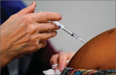  ?? (AP/Matt Rourke) ?? A health worker administer­s a dose of a covid-19 vaccine Wednesday during a vaccinatio­n clinic at the Keystone First Wellness Center in Chester, Pa.