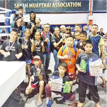  ??  ?? ALL SMILES: Nazri (back, fourth left) with some of the winners at the recent Sabah Youth Muaythai Championsh­ip in Papar.