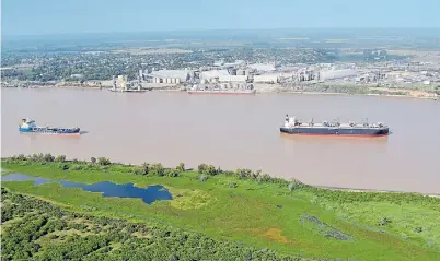  ??  ?? El río es ancho y ajeno. Barcos paraguayos, bolivianos y uruguayos son los mayores transporti­stas fluviales.