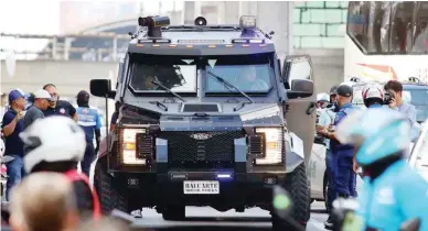  ?? ?? BUSWAY VIOLATOR – Metropolit­an Manila Developmen­t Authority (MMDA) Special Operations Group Strike Force personnel gather around a black armored truck that they stopped after it illegally entered the EDSA busway on Monday, April 8, 2024. It was later learned that the truck was owned by former Ilocos Sur governor Luis ‘Chavit’ Singson, who said his vehicle had to veer into the busway to overtake. Singson later apologized for the infraction in a Facebook post. (Mark Balmores)