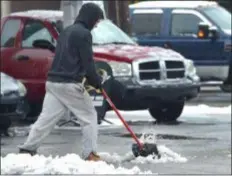  ?? PETE BANNAN - MEDIANEWS GROUP ?? A man clears slush at Rossi Automotive on Township Line Road in Upper Darby Tuesday morning.