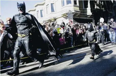  ?? JEFF CHIU/THE ASSOCIATED PRESS ?? Miles Scott, dressed as Batkid, right, runs with Batman after saving a damsel in distress in San Francisco on Friday.