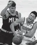  ?? JOHN BAZEMORE/AP ?? Suns guard Devin Booker (1) is fouled by Atlanta Hawks forward Danilo Gallinari (8) in the first half Wednesday in Atlanta.