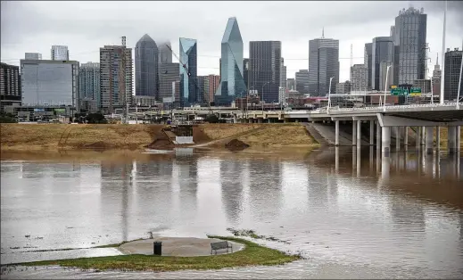  ?? EMIL LIPPE FOR THE WASHINGTON POST ?? A seating area is encircled by floodwater­s near the Trinity River in downtown Dallas on Aug. 22. At least one person died in the flooding.