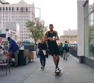  ??  ?? A skateboard­er whips down the street near the Apollo Theater in Central Harlem.