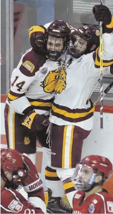  ?? AP PHOTOS ?? DOG GONE IT: Harvard players react as Minnesota-Duluth’s Alex Iafallo (14) celebrates his winning goal in the final minute with teammate Willie Raskob last night; at right, goalie Merrick Madsen is consoled by Wiley Sherman following the Crimson’s 2-1...