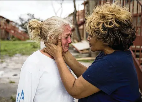  ?? PHOTOS BY NICK WAGNER / AMERICAN-STATESMAN ?? Genice Gipson holds her lifelong friend, Loretta Capistran, outside of Capistran’s apartment complex in Refugio on Monday. “We got to be strong, baby,” Gipson told Capistran. Almost every structure in the city appears to have sustained some damage.