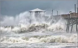  ?? AP ?? Waves slam a pier at Atlantic Beach, North Carolina, on Thursday.