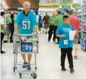  ?? MIKE STOCKER/SOUTH FLORIDA SUN SENTINEL ?? Former Miami Dolphins player Larry Ball shops with kids at the Publix in downtown Fort Lauderdale for a Thanksgivi­ng meal.