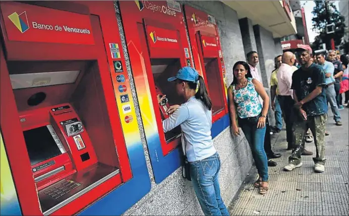  ?? NACHO DOCE / REUTERS ?? Cola para sacar dinero de un cajero automático, el pasado viernes en Caracas. La cesta de la compra se ha encarecido un 220% en un año y los sueldos han subido solo el 45%