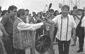  ?? Photo by Redjie Melvic Cawis ?? UNITY GONG TURN OVER. Ifugao delegates led by Governor Pedro Mayamo turns over the Cordillera Unity Gong to Mountain Province Gov. Bonifacio Lacwasan Jr. at the boundary of Banaue, Ifugao and Bontoc Mountain Province. The gong relay was conceived by...