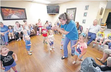  ??  ?? Shelby Farnsworth leads children in a “Rhythm and Rhyme” dance at the Yukon Community Center.