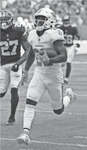  ?? JIM RASSOL/THE PALM BEACH POST ?? Miami Dolphins running back De’Von Achane (28) breaks free for a 76-yard touchdown run against the New York Giants during the first half on Sunday at Hard Rock Stadium in Miami Gardens.