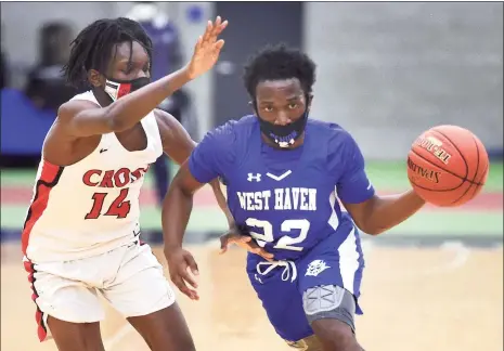  ?? Arnold Gold / Hearst Connecticu­t Media ?? West Haven’s Eli Blackwell, right, is defended by Wilbur Cross’ Namumba Santos in the first half on Friday.