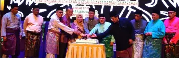  ??  ?? Julaihi (centre), flanked by Rubiah on his right and Mohammad Ali, leads the cake-cutting ceremony at the joint Gawai-Raya event. Idris is at fourth right.