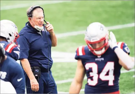  ?? Kathryn Riley / Getty Images ?? Patriots coach Bill Belichick, left, looks on during Sunday’s game against the Raiders. Running back Rex Burkhead (34) scored three touchdowns in the win, Belichick’s 275th career regular-season victory.