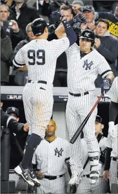  ?? Kathy Willens ?? The Associated Press Yankees slugger Aaron Judge (99) is congratula­ted by teammate Gary Sanchez after hitting a home run in the seventh inning of Game 4 of the American League Championsh­ip Series against the Houston Astros on Tuesday in New York.