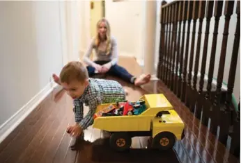  ?? NICK KOZAK/FOR THE TORONTO STAR ?? Adeston Martin, 2, and his mom, Guinevere Orvis, at their Toronto home. He’s playing with the restored Tonka truck his mother had when she was a kid.