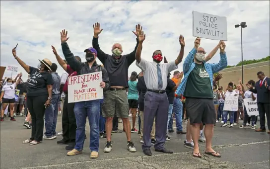  ?? Steve Mellon/Post-Gazette ?? Several pastors raise their hands in prayer at the conclusion of a protest Wednesday at Southland Shopping Center in Pleasant Hills. About 250 people gathered to protest the death of George Floyd in Minneapoli­s.