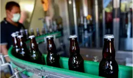  ?? AFP ?? This picture taken on February 24, 2017 shows a worker watching as bottles roll by at the Stark Beer factory in Singaraja, a regency on Indonesia's Bali island —