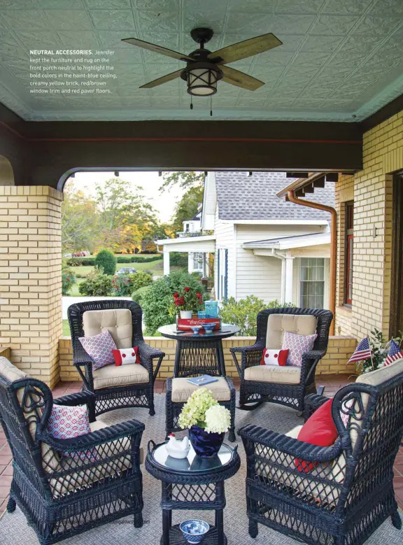  ??  ?? NEUTRAL ACCESSORIE­S. Jennifer kept the furniture and rug on the front porch neutral to highlight the bold colors in the haint-blue ceiling, creamy yellow brick, red/brown window trim and red paver floors.