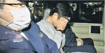 ??  ?? File photo shows suspect Shiraishi (centre) covering his face with his hands as he is transporte­d to the prosecutor’s office from a police station in Tokyo. — AFP photo