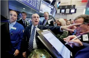  ?? AP ?? New York Stock Exchange floor governor Nicholas Brigandi on the trading grounds on Friday, when US stock indexes inched higher as energy companies clawed back some of their sharp losses from earlier in the week. —